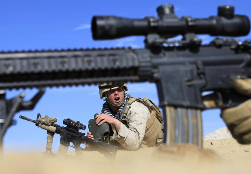 A U.S. Marine from Bravo Company, 1st Battalion, 6th Marines gestures during a gun battle in the town of Marjah, in Nad Ali district, Helmand province, February 13, 2010. (Xinhua/Reuters Photo)