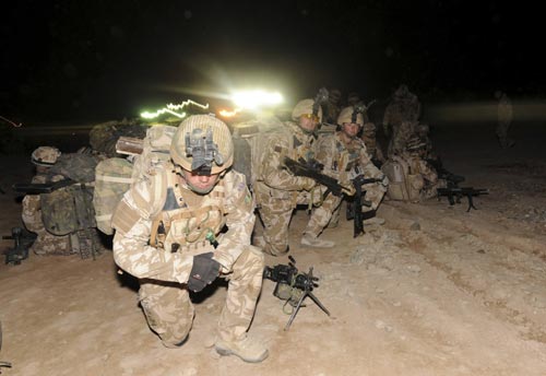 Corporal Lino Woolf, 24-years-old from Weymouth, keeps a firm grasp of his search dog before being mobilised for Operation Moshtarak, a combined force of 15,000 troops launching major assaults on Taliban strongholds in Helmand Province, at Camp Bastion, Afghanistan February 13, 2010. U.S.-led NATO troops launched a crucial offensive on Saturday against the Taliban&apos;s last big stronghold in Afghanistan&apos;s most violent province and were quickly thrown into a firefight with the militants. [Xinhua]