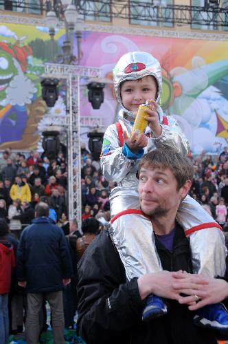 A father brings his child to a parade during the 126th edition of the Nice carnival in Nice, France, on Feb. 21, 2010. The 126th Nice Carnival which takes place from Feb. 12 till Feb. 28 came to a climax on Sunday. A total of 20 floats joined the parade and lots of people took part in it.