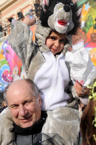 A father brings his child to a parade during the 126th edition of the Nice carnival in Nice, France, on Feb. 21, 2010. The 126th Nice Carnival which takes place from Feb. 12 till Feb. 28 came to a climax on Sunday. A total of 20 floats joined the parade and lots of people took part in it.