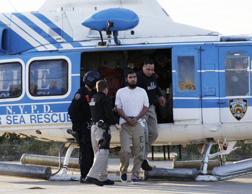 Najibullah Zazi (C) is escorted by U.S. Marshals after a helicopter landing at a New York Police Department facility in Brooklyn, New York, September 25, 2009. Zazi was flown from Denver, Colorado, earlier in the day and will be held in New York until a September 29 hearing at a U.S. District Court. Zazi, who was arrested on September 19, is charged with plotting bomb attacks in the United States. Picture taken September 25, 2009.[Xinhua] 