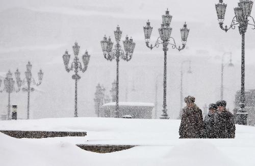 Pedestrians walk on a snow-covered road near the Red Square in Moscow, capital of Russia, Feb. 22, 2010. Moscow has been blanketed with some 45.4 cm of snow over the last four days in a rare case in decades, the Moscow Weather Service said on Monday. [Xinhua]