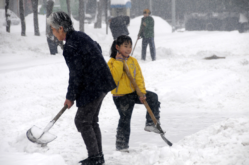 People clear snow on the road in Kuitun City, northwest China's Xinjiang Uygur Autonomous Region, Feb. 23, 2010. (Xinhua/Long Haibo)