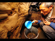 A villager gets water from a cave in Fengyan Village of Xingren County, southwest China's Guizhou Province, on February 24, 2010. Over 1.53 million people and 756 thousand of livestock fall short of water due to long-term lack of rainfall. 4.17 million mu of crops by Tuesday are affected, with 2.65 million mu seriously damaged and 300 thousand mu destroyed completely in the province. [Xinhua]