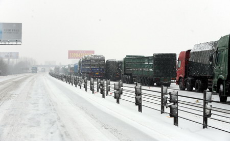 Trucks are stranded after highways closed due to snowfall on the line from Harbin to Datong in northeast China's Heilongjiang province, February 24, 2010.[Xinhua] 