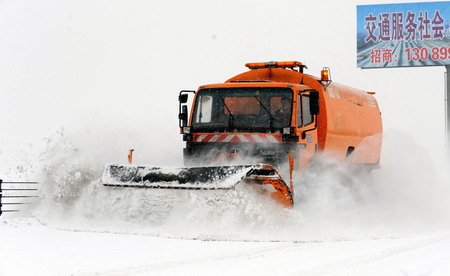 A snowplow cleans the Harbin-to-Datong freeway in northeast China's Heilongjiang province, February 24, 2010.[Xinhua]