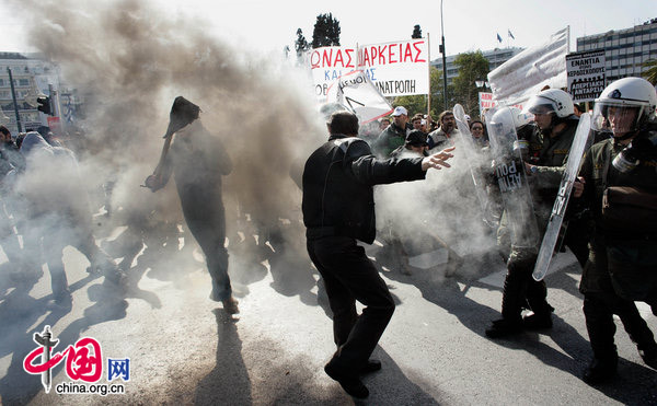  Protesters clash with the police during a protest march to mark a 24-hour general strike on February 24, 2010 in Athens, Greece. Greece ground to a halt and flights were grounded as unions staged a one-day general strike in protest against Government&apos;s austerity measures designed to contain the massive public deficit. [CFP]