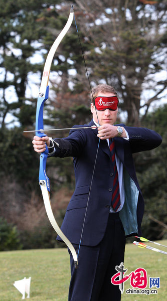 Prince William takes part in an archery lesson - wearing a blindfold to simulate loss of eyesight - at St Dunstan&apos;s, a specialist centre for blind ex-Service and women, in Llandudno, North Wales on February 22, 2010. [CFP]