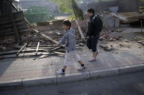 A man and a boy walk on the street after a 8.8-magnitude earthquake in Santiago, capital of Chile, Feb. 27, 2010. [Xinhua] 