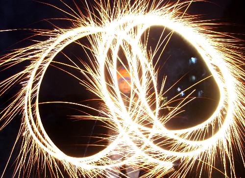 A boy waves firework in a street in Heze, east China's Shandong Province, Feb. 28, 2010, the Chinese traditional Lantern Festival. (Xinhua)