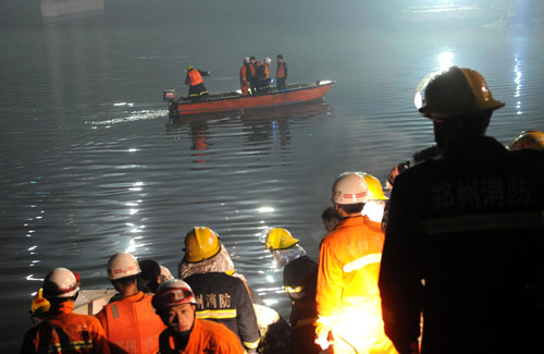 Rescuers in a boat search for survivors of the bus accident in Zhengzhou, February 28, 2010. [Photo/Xinhua]