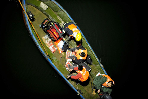 The position of the plunged bus is located by rescuers in Zhengzhou, February 28, 2010. [Photo/Xinhua] 