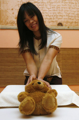 A teddy bear gets a traditional Thai massage in Prague February 27, 2010.[Xinhua/Reuters] 