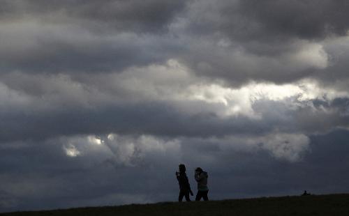 Two girls under gathering heavy clouds near Frankfurt, Feb. 28, 2010. Storm &apos;Xynthia&apos; caused serious damage to Germany, resulting in sectional disruption of rail and flight traffic. A fierce storm swept western Germany Sunday amid gusts of over 100 kilometers per hour, at least 3 people killed, many trees toppled and hundreds of flights and trains suspended. [Xinhua/Reuters]