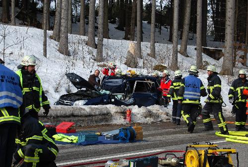 Firemen stand next to a car, damaged by a tree cut down by heavy storm in Frankfurt February 28, 2010. The severe storm &apos;Xynthia&apos; that swept through much of France brought about damage in parts of Germany. [Xinhua/AFP]