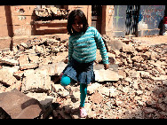 A Chilean girl walks past a destroyed building in Santiago, Chile, Feb. 28, 2009. More than 300 people are killed in Chile after a 8.8-magnitude megaquake hit the country on Saturday, the national emergency office said. [Xinhua]