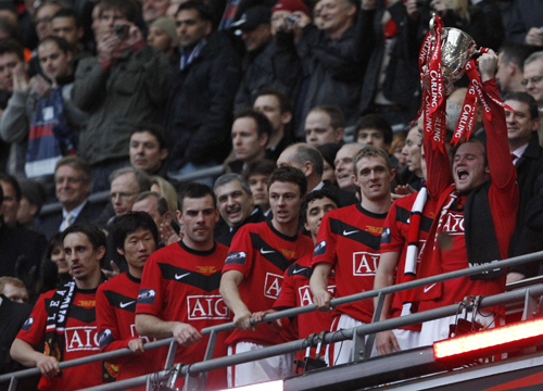 Manchester United's Wayne Rooney (R) lifts the trophy after beating Aston Villa in the English League Cup final soccer match at Wembley Stadium in London February 28, 2010. (Xinhua/Reuters Photo)