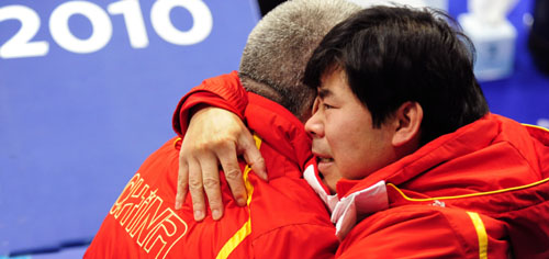 China's coach Daniel Rafael (L) and Tan Weidong hug to celebrate after the women's curling bronze medal match with Switzerland at the 2010 Winter Olympic Games in Vancouver, Canada, Feb. 26, 2010. [Xinhua/Chen Xiaowei]