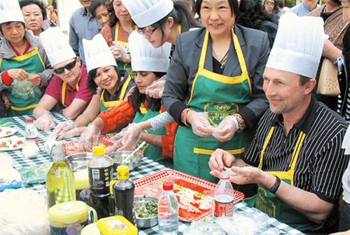 Expat residents in Changning District learn to make jiaozi (Chinese dumpling stuffed with sliced pork and vegetables) at a community event. (Shanghai Daily photo)