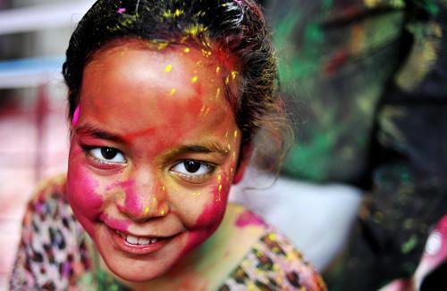 A girl with her face smeared in color is seen during the celebrations of Holi, at a temple in New Delhi, India, Mar. 1, 2010. The tradition of Holi, also known as Festival of Colors, marking the beginning of spring was celebrated all over India. [Xinhua]