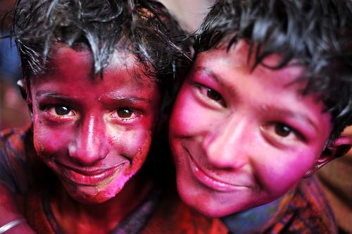 Boys with their faces smeared in color smile during the celebrations of Holi, at a temple in New Delhi, India, Mar. 1, 2010. The tradition of Holi, also known as Festival of Colors, marking the beginning of spring was celebrated all over India. [Xinhua]