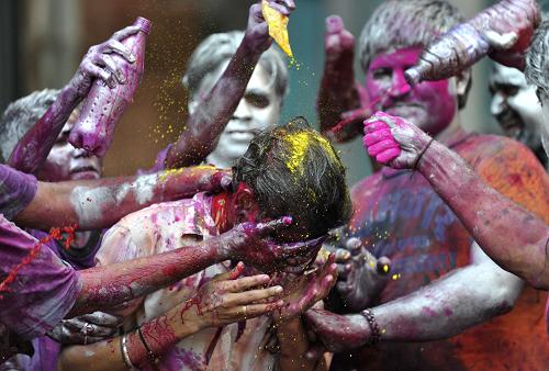 Hindu devotees celebrate Holi, also known as the festival of colours, outside a temple on the outskirts of the northern Indian city of Mathura March 1, 2010.[Xinhua/Reuters]