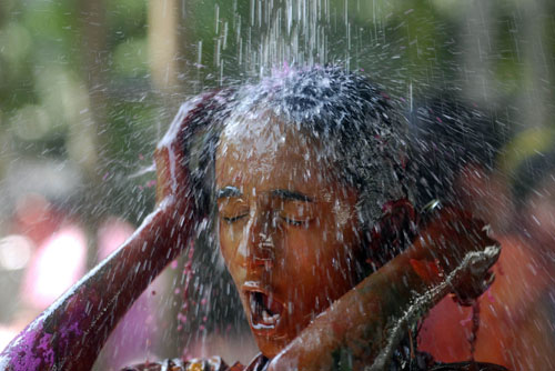 A girl washes herself after taking part in Holi, also known as the festival of colours, in the southern Indian city of Hyderabad February 28, 2010.[Xinhua/Reuters]