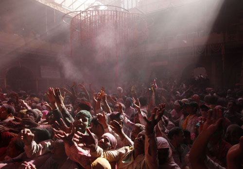 Hindu devotees celebrate Holi, also known as the festival of colours, outside a temple on the outskirts of the northern Indian city of Mathura March 1, 2010.[Xinhua/Reuters]