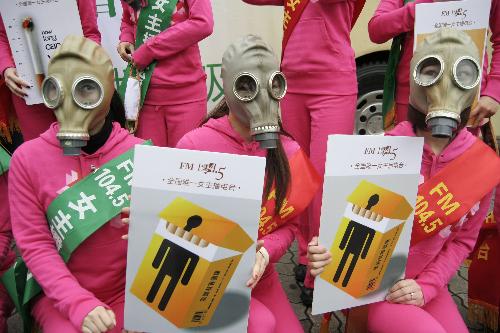 Radio hostesses wearing masks and holding anti-smoking posters pose for photo in Hangzhou, capital of east China&apos;s Zhejiang Province, March 1, 2010. [Xinhua]