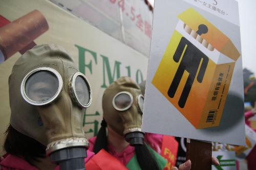 Radio hostesses wearing masks hold anti-smoking posters in Hangzhou, capital of east China&apos;s Zhejiang Province, March 1, 2010. [Xinhua]