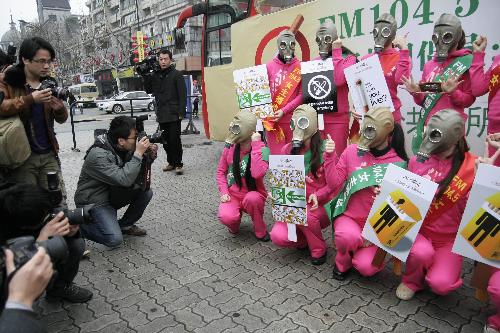 Radio hostesses wearing masks and holding anti-smoking posters pose for photo in Hangzhou, capital of east China&apos;s Zhejiang Province, March 1, 2010. [Xinhua]