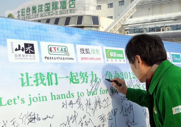 Huang signs a board on March 1 urging China to hold the 2010 UN climate change conference, in Dezhou of Shandong province. [CFP]