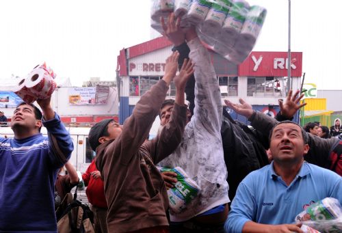 People loot merchandise outside a shop in the quake-devastated Concepcion, Chile, March 1, 2010. Chilean security forces Monday arrested dozens of looters in Concepcion as hundreds of looters ransacked shops for food and other goods. The 8.8-magnitude quake occurring Saturday has killed over 700 people in Chile. [Martin Zabala/Xinhua] 