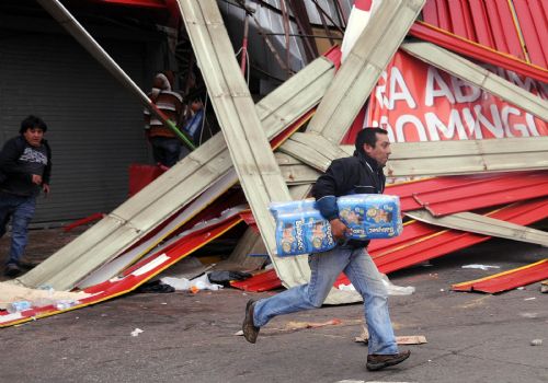 A looter runs away with merchandise he stole from a shop in the quake-devastated Concepcion, Chile, March 1, 2010. Chilean security forces Monday arrested dozens of looters in Concepcion as hundreds of looters ransacked shops for food and other goods. The 8.8-magnitude quake occurring Saturday has killed over 700 people in Chile. [Martin Zabala/Xinhua] 