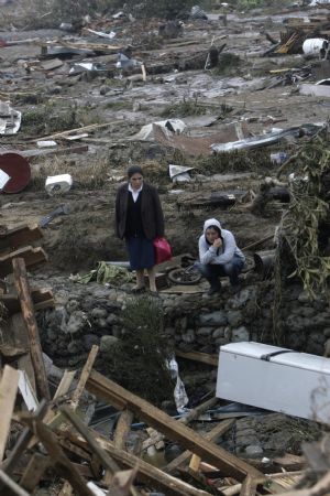 Women look for their relatives in earthquake-and-tsunami-devastated Dichato town, some 30 kilometers north of Concepcion, Chile, March 1, 2010. The death toll from the 8.8-magnitude earthquake that hit Chile early Saturday has reached 723, the Chilean government said on Monday. More than 500 people were injured and at least 19 people are still unaccounted for, the National Emergency Office (Onemi) said. [Victor Rojas/Xinhua]
