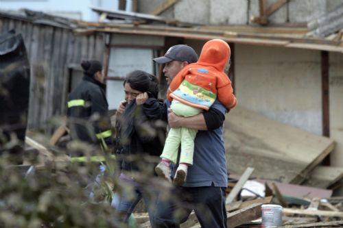 People walk on a street in earthquake-and-tsunami-devastated Dichato town, some 30 kilometers north of Concepcion, Chile, March 1, 2010. The death toll from the 8.8-magnitude earthquake that hit Chile early Saturday has reached 723, the Chilean government said on Monday. More than 500 people were injured and at least 19 people are still unaccounted for, the National Emergency Office (Onemi) said.[Victor Rojas/Xinhua]
