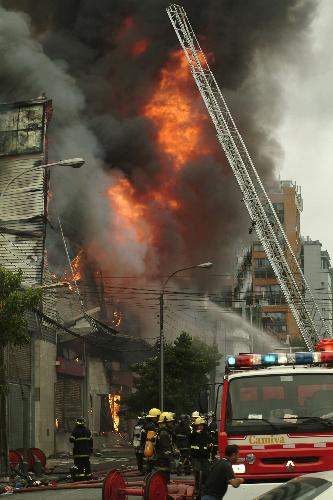 Firemen fight a fire in a building damaged by a major earthquake in Concepcion March 1, 2010. Chile&apos;s government scrambled on Monday to provide aid to thousands of homeless people in coastal towns devastated by a massive earthquake and tsunamis, as 10,000 troops patrolled to quell looting. [Xinhua] 