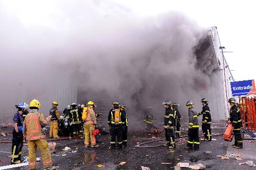 Firemen fight a fire in a supermarket in Concepcion, Chile. Angry and hungry Chileans set fire to shops in the quake-hit city of Concepcion Monday as President Michelle Bachelet rushed 5,000 extra troops to the disaster zone to maintain order. [Xinhua] 