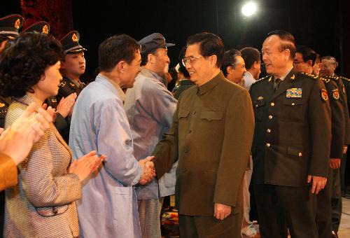 Hu Jintao (C), general secretary of the Central Committee of the Communist Party of China, Chinese president and chairman of the Central Military Commission, meets with performers after watching a drama honoring Liu Yiquan, late file clerk at the archives of the People's Liberation Army, in Beijing, capital of China, March 2, 2010. [Wang Jianmin/Xinhua]