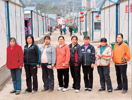 Pregnant women pose for a picture in front of their temporary shelters at Qushan town in Beichuan county, Sichuan province. [China Daily]