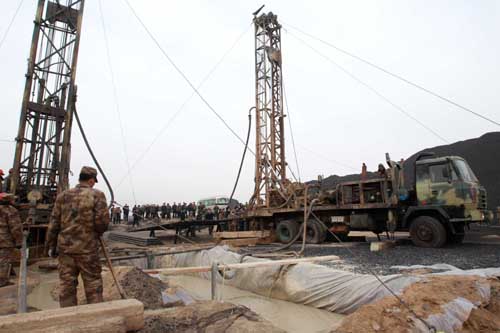 Rescuers are working all-out to drain water from a flooded pit of Luotuoshan Coal Mine in Wuhai City, north China's Inner Mongolia Autonomous Region, March 2, 2010, hoping to lift 31 people out of the pit. Water gushed into the pit of Luotuoshan Coal Mine in Wuhai City, at least 600 kilometers from the regional capital Hohhot at around 7:30 a.m. Monday, the local work safety authority said. [Pang Xinglei/Xinhua]