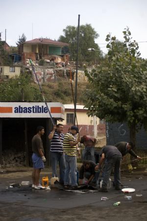 People search for oil at a destroyed gas station after tsunami and the 8.8-magnitude earthquake in Lota Port, 60km south Concepcion, Chile, March 2, 2010. Chilean President Michelle Bachelet said Tuesday that the death toll from Saturday's devastating earthquake had reached 795. [Victor Rojas/Xinhua]