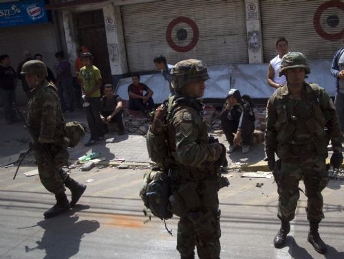 Military forces take under arrest some looters after tsunami and the 8.8-magnitude earthquake in Lota Port, 60km south Concepcion, Chile, March 2, 2010. Chilean President Michelle Bachelet said Tuesday that the death toll from Saturday's devastating earthquake had reached 795. [Victor Rojas/Xinhua]