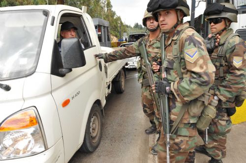 Soldiers check a car at a tolling station in Concepcion, Chile, March, 2, 2010. Thousands of soldiers have been deployed in Concepcion as the lack of power, drinking water and food caused panic among residents in Concepcion, triggering looting in supermarkets and food stores. [Song Weiwei/Xinhua] 