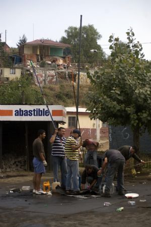 People search for oil at a destroyed gas station after tsunami and the 8.8-magnitude earthquake in Lota Port, 60km south Concepcion, Chile, March 2, 2010. Chilean President Michelle Bachelet said Tuesday that the death toll from Saturday&apos;s devastating earthquake had reached 795. [Victor Rojas/Xinhua]