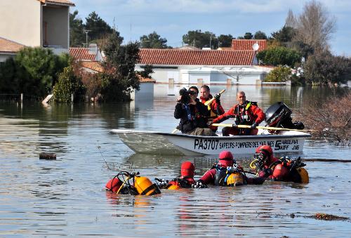 Rescue workers search for the missing in a flooded residential neighborhood in La-Faute-sur-Mer, western France, March 2, 2010 after a major storm named Xynthia hit western Europe, killing at least 62. [Xinhua] 