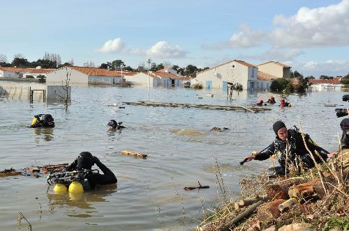 Rescue workers search for the missing in a flooded residential neighborhood in La-Faute-sur-Mer, western France, March 2, 2010 after a major storm named Xynthia hit western Europe, killing at least 62. [Xinhua] 