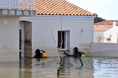 Rescue workers search for the missing in a flooded residential neighborhood in La-Faute-sur-Mer, western France, March 2, 2010 after a major storm named Xynthia hit western Europe. [Xinhua] 