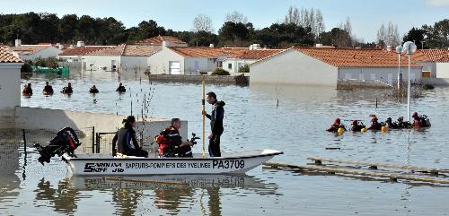 Rescue workers search for the missing in a flooded residential neighborhood in La-Faute-sur-Mer, western France, March 2, 2010 after a major storm named Xynthia hit western Europe, killing at least 62 as of March 2. [Xinhua] 