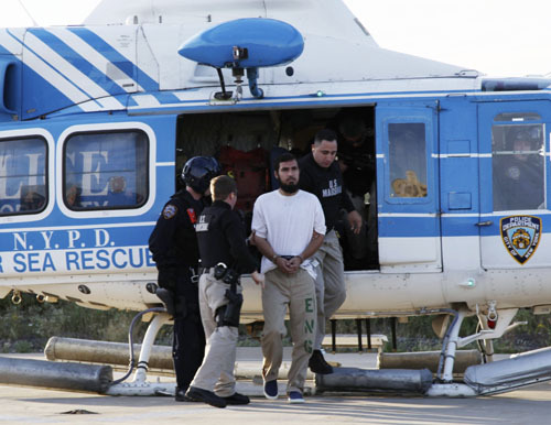 Najibullah Zazi (C) is escorted by US Marshals after a helicopter landing at a New York Police Department facility in Brooklyn, New York, September 25, 2009. Zazi was flown from Denver, Colorado, earlier in the day and will be held in New York until a September 29 hearing at a US District Court. Zazi, who was arrested on September 19, is charged with plotting bomb attacks in the United States. [Xinhua photo]